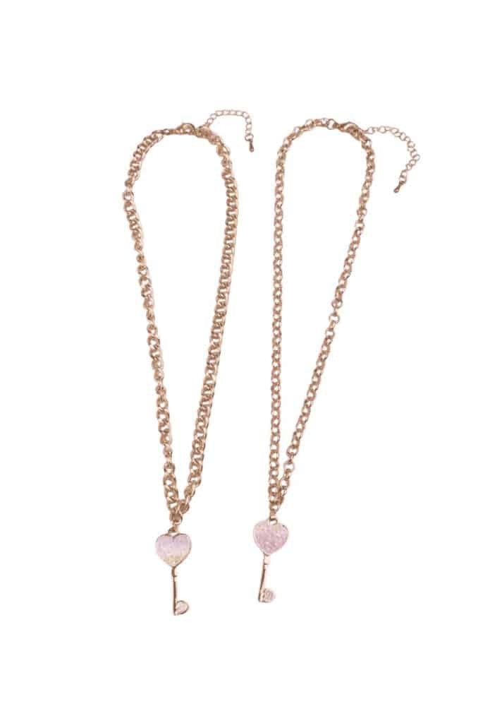 Sleutel naar mijn hart ketting met twee gouden kettingen en roze hartvormige sleutelbedels, los op een witte achtergrond
