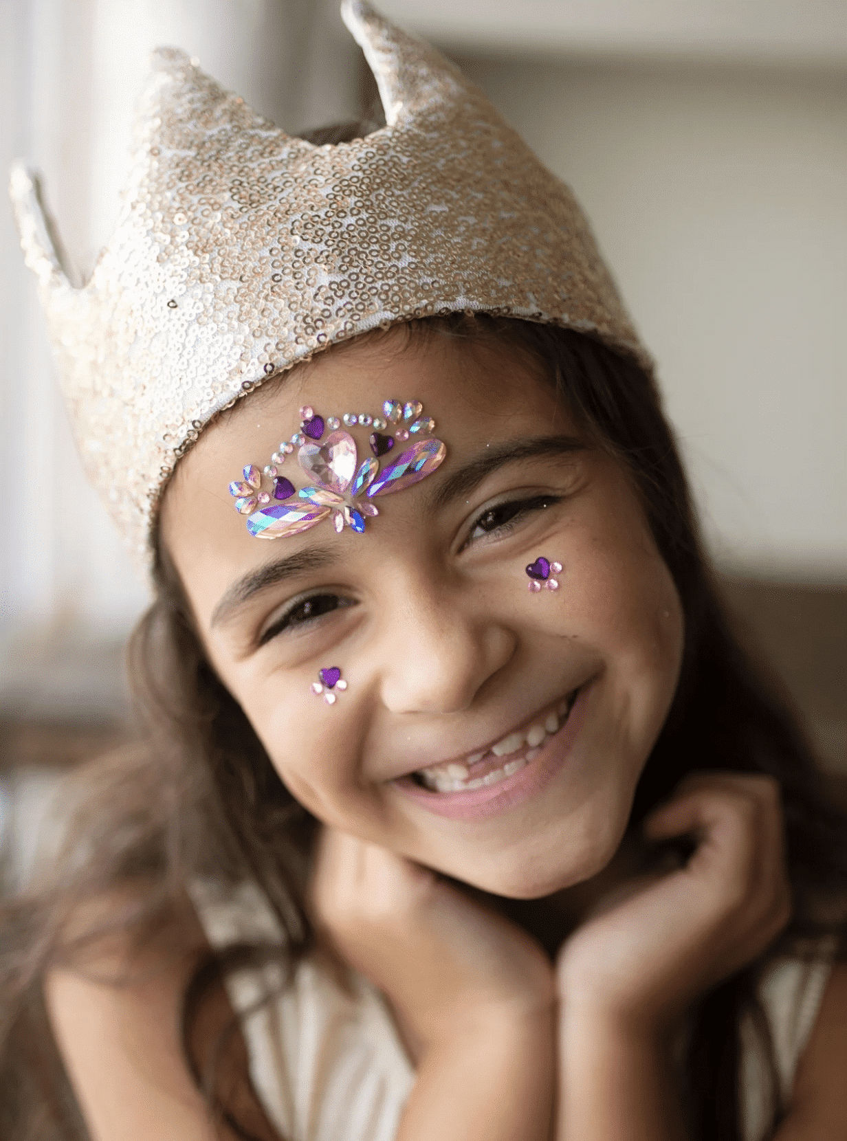 Meisje draagt de gouden tiara van Great Pretenders, bedekt met glanzende pailletten en puntige uiteinden.