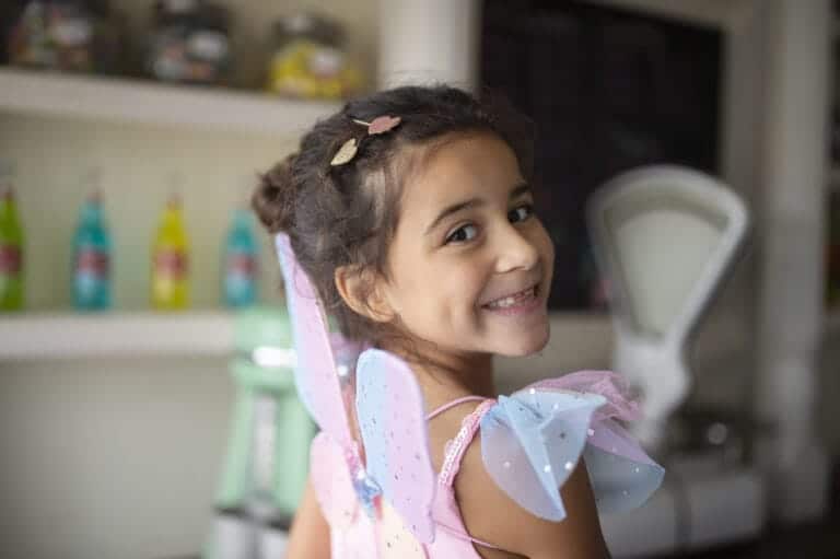 Meisje met de Great Pretenders haarclips ster en hartje in haar donkere haar, glimlachend met vleugels op haar rug.