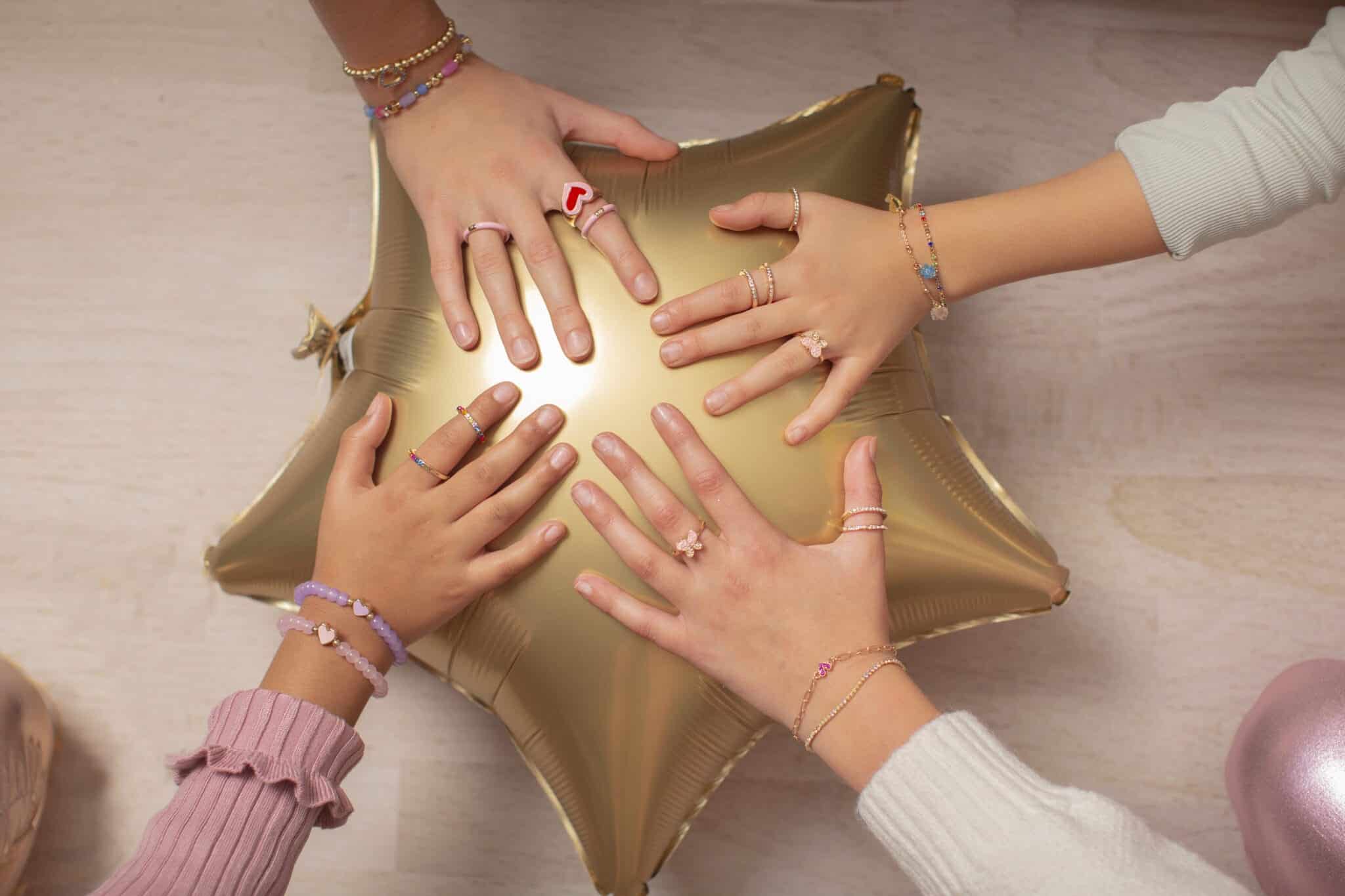 Prinsessensieraden van Great Pretenders: kinderen dragen kleurrijke vlinderringen rond een gouden sterballon