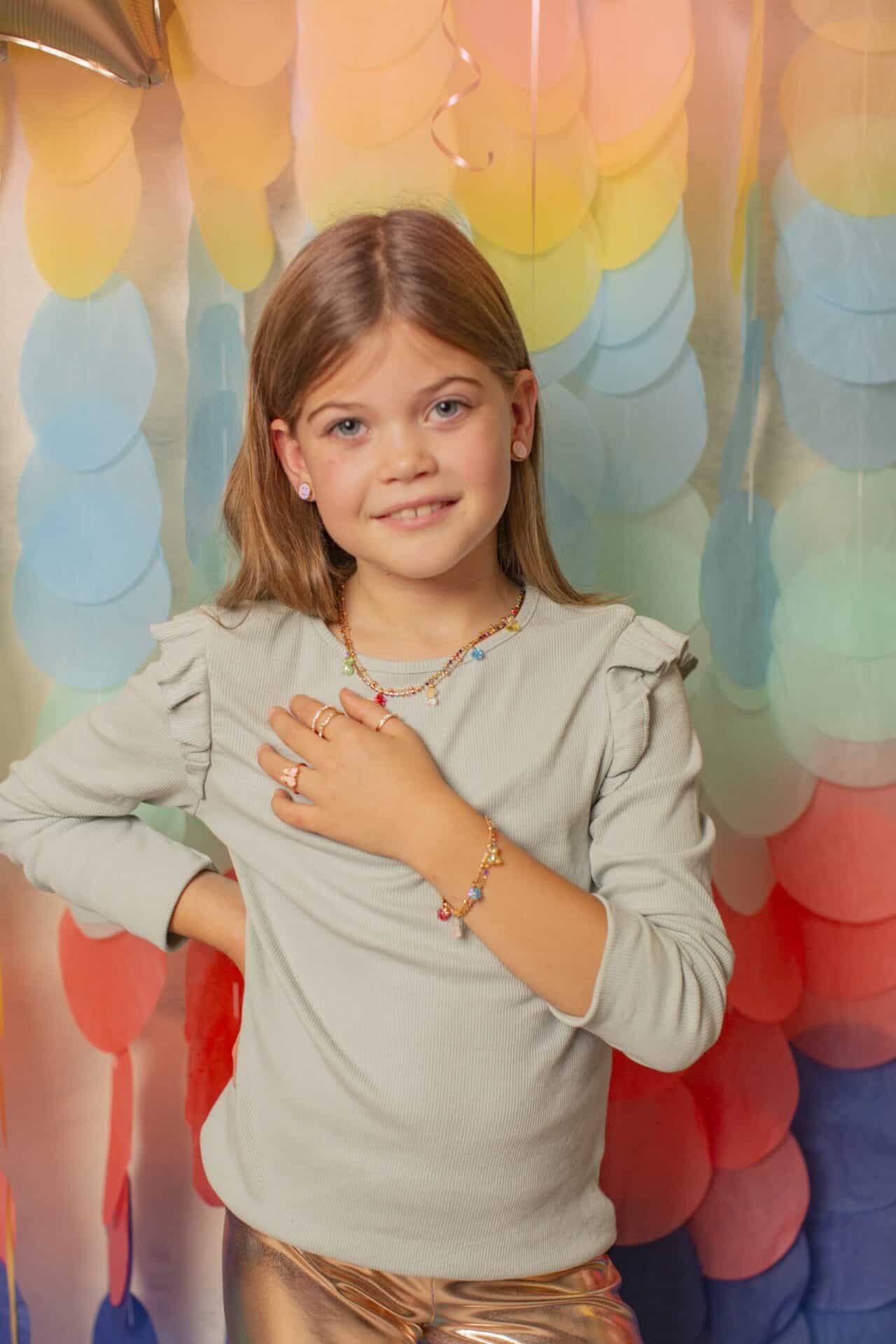 Meisje draagt de Great Pretenders Gummybeertje ketting met kleurrijke hangers en een bijpassende armband