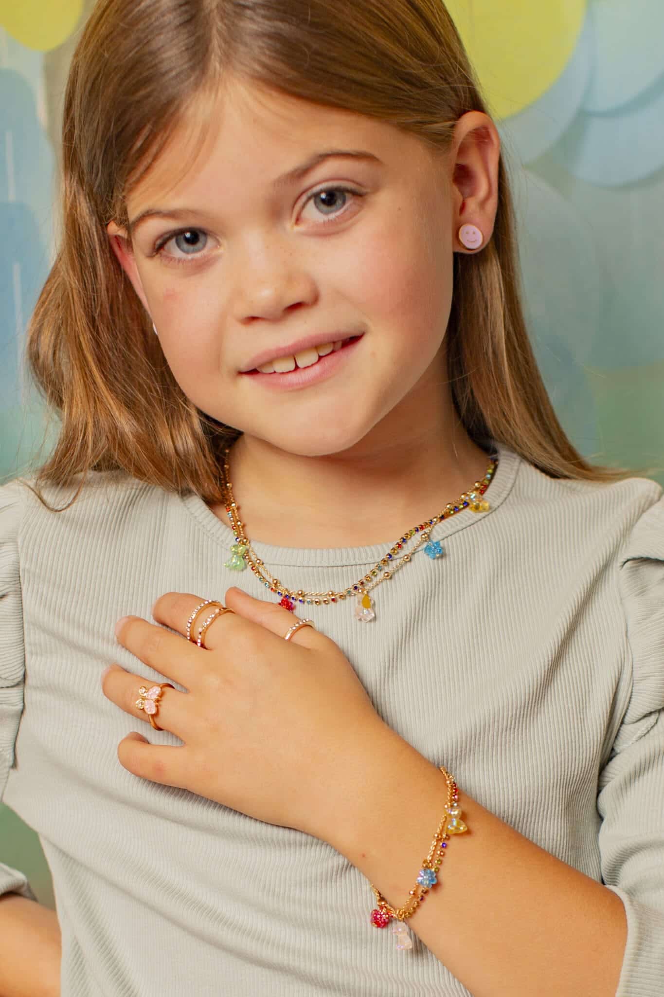 Meisje draagt de Gummybeertje ketting van Great Pretenders met kleurrijke hangertjes en bijpassende armband