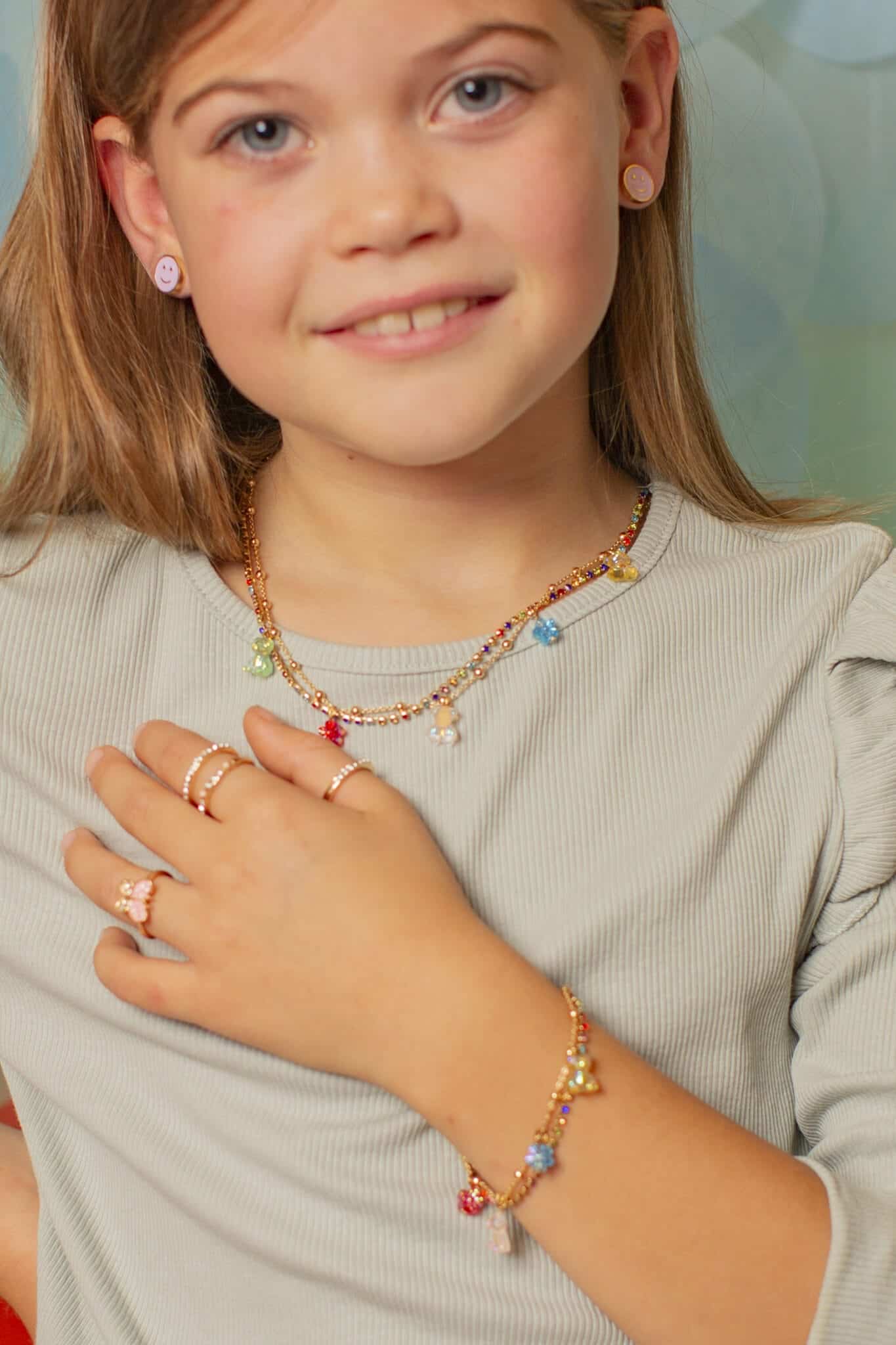 Close-up van een meisje met de Gummybeertje ketting en kleurrijke hangers, onderdeel van haar prinsessensieraden.