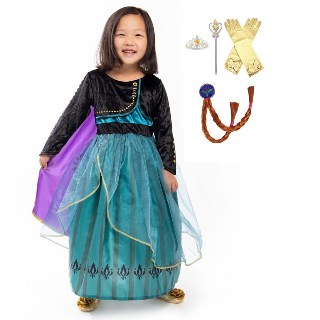 Meisje draagt een turquoise en paarse Anna jurk met zwarte mouwen, gouden details en bijpassende accessoires.