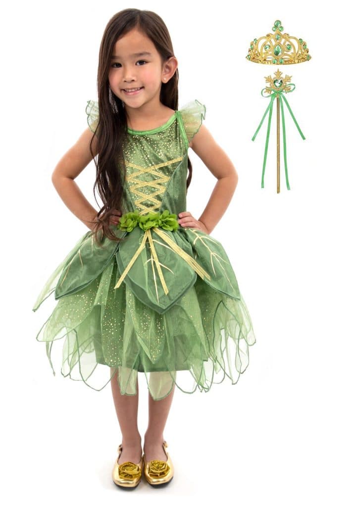 Meisje draagt een groene tinkerbell jurk met bladrok; kroon en toverstaf staan naast haar.
