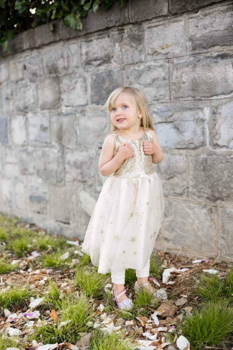 Meisje draagt een witte Golden Glam prinsessenjurk met gouden paillettenlijfje en sterren op de rok.