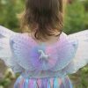 Kind draagt een unicorn jurk kind met pastelregenboogrok en brede glittervleugels, van achteren gezien.