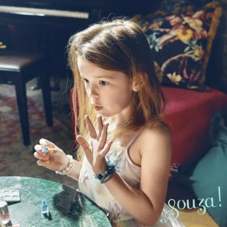 Meisje gebruikt kinder make up uit de Souza beautycase aan tafel