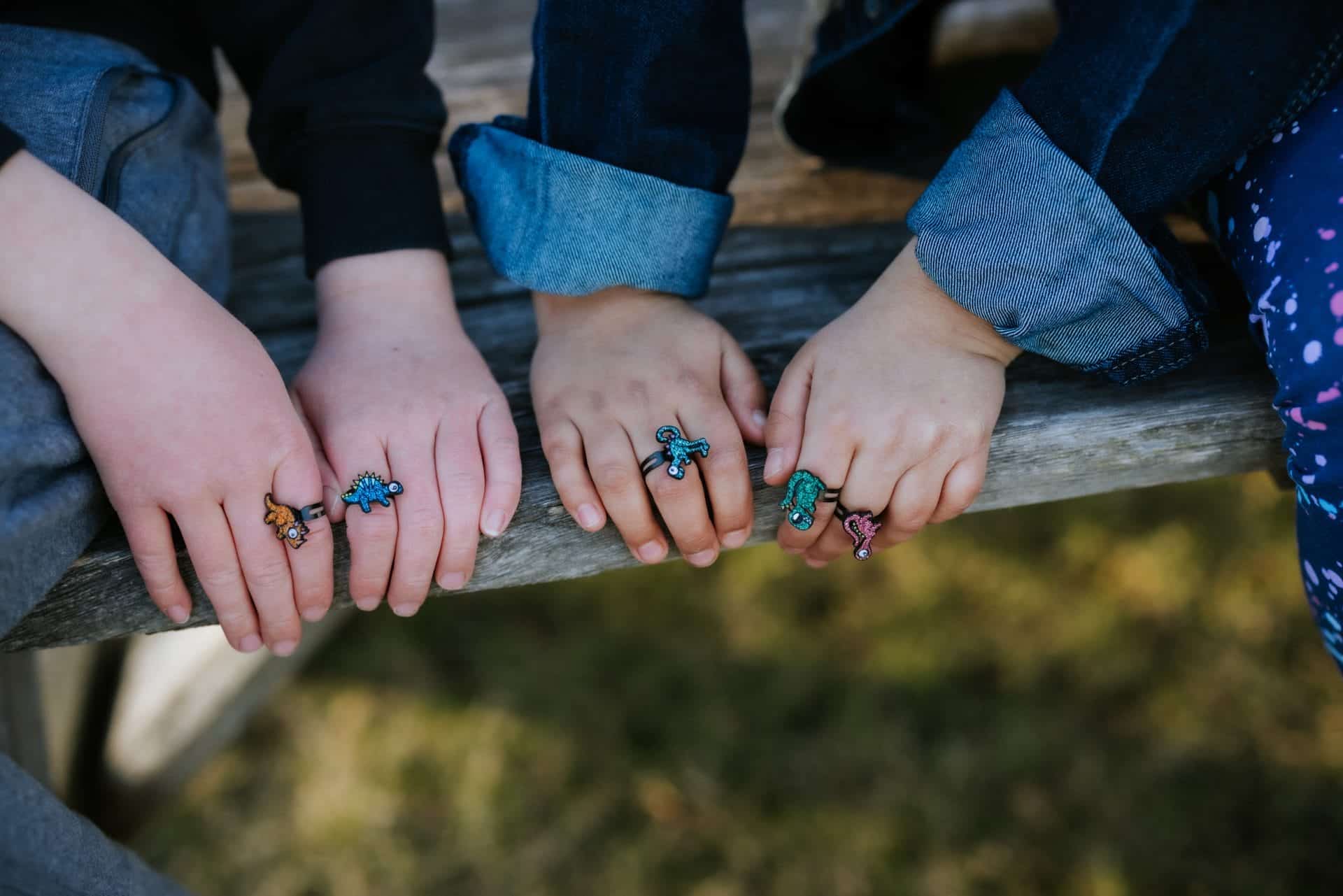 Kinderen dragen kleurrijke spinner ring uit de set van zes soorten, met dierenfiguren aan hun vingers