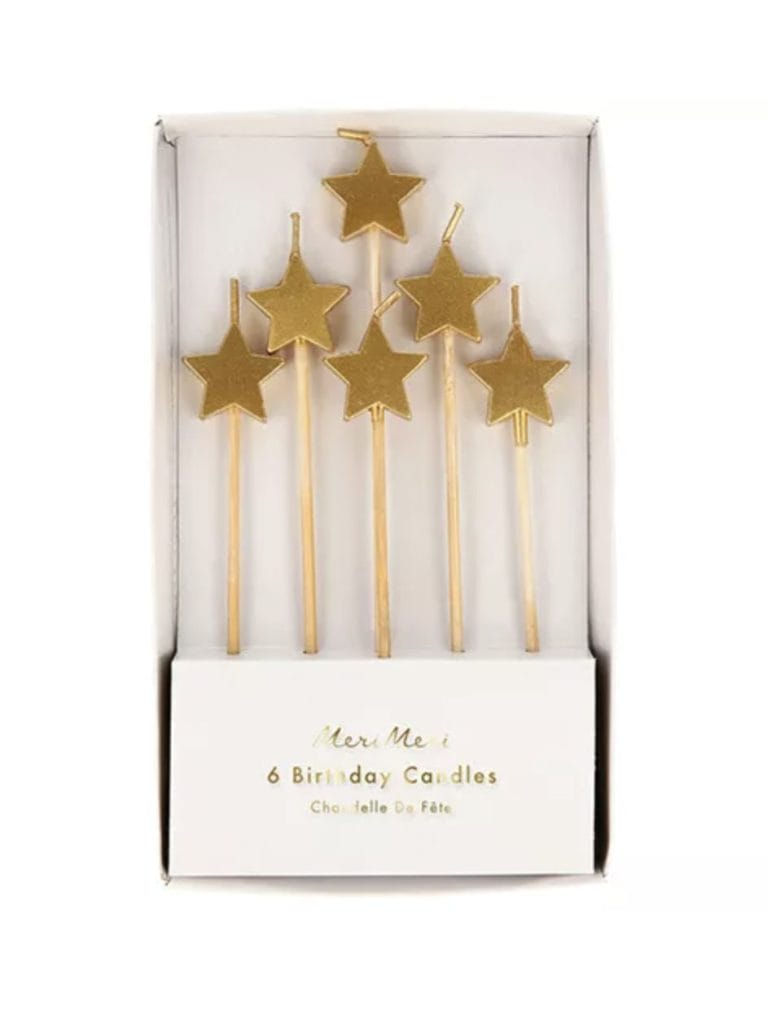 Zes gouden sterren kaarsjes op kunststof stokjes in een open Meri Meri verpakking.