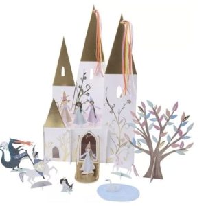 Prinsessen kasteel van Meri Meri met gouden torens, kleurrijke linten, een boom en kleine figuren op witte achtergrond.