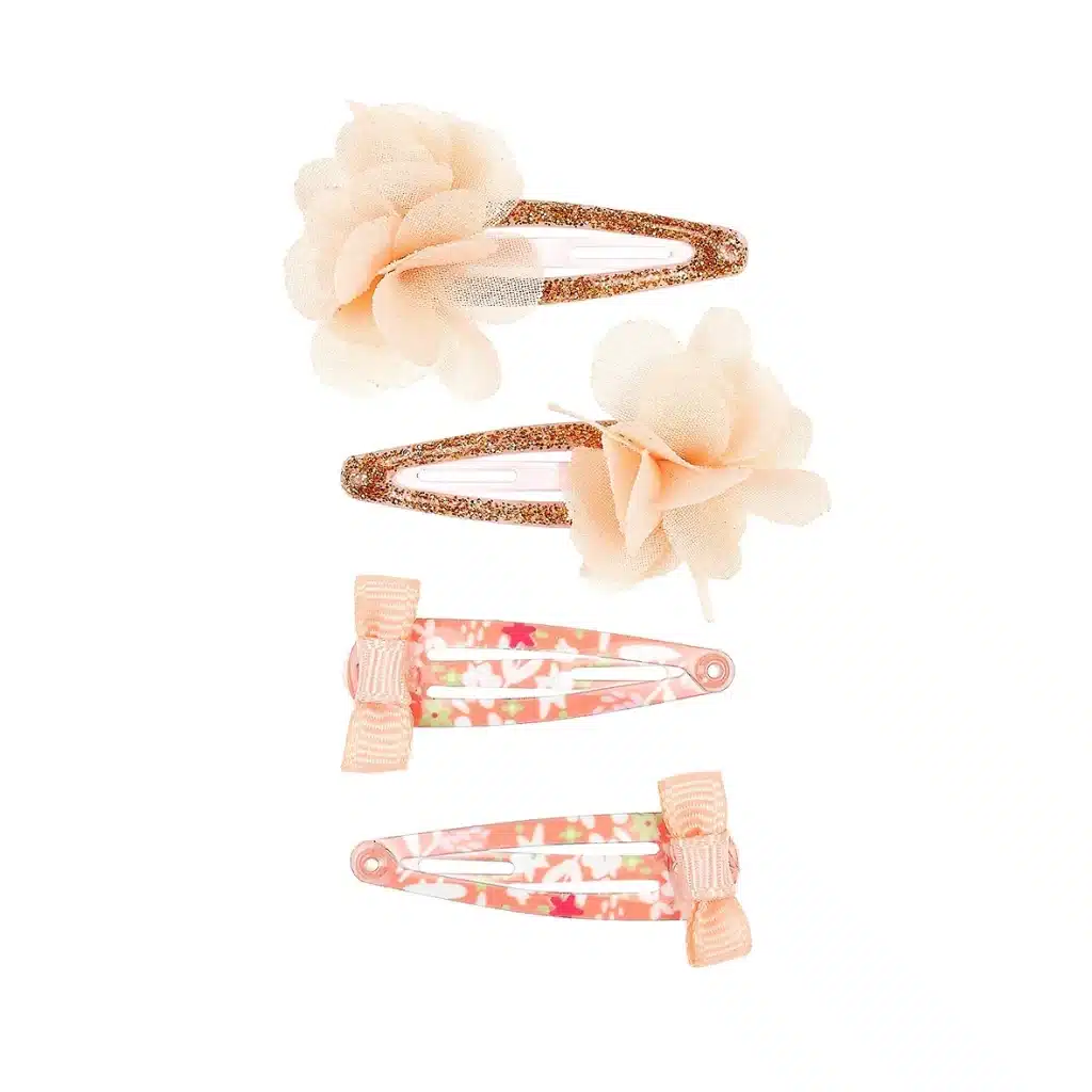 Vier gouden haarclips Avia met grote bloemen en roze clips met strikjes, liggend naast elkaar op een witte achtergrond.