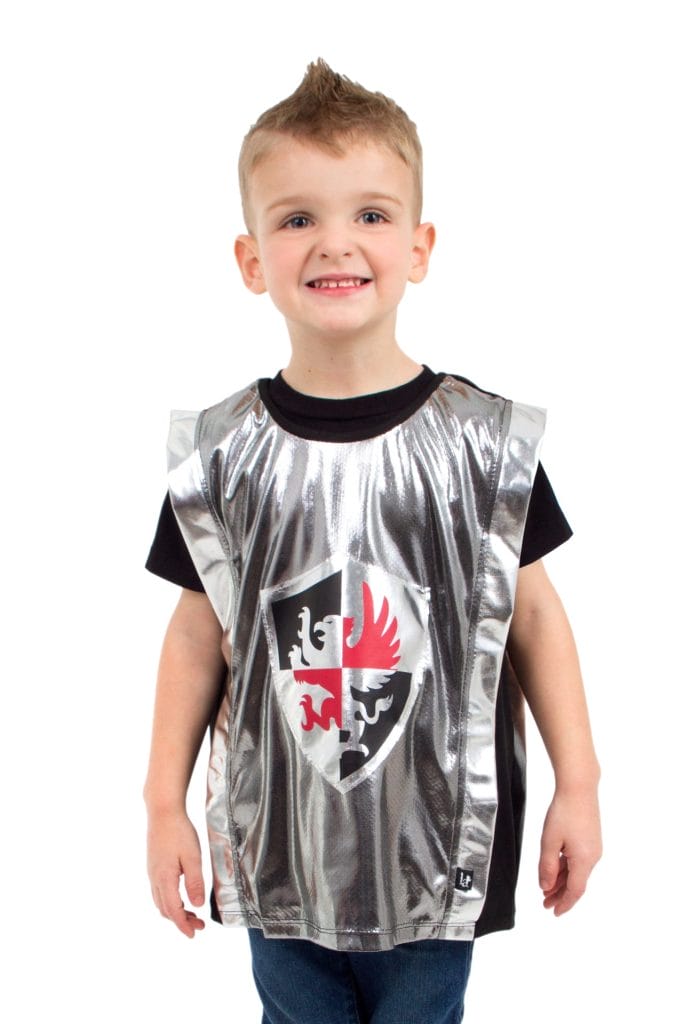 Jongen draagt een glanzend zilveren ridder vest van Little Adventures met zwart-rood schild op de voorkant