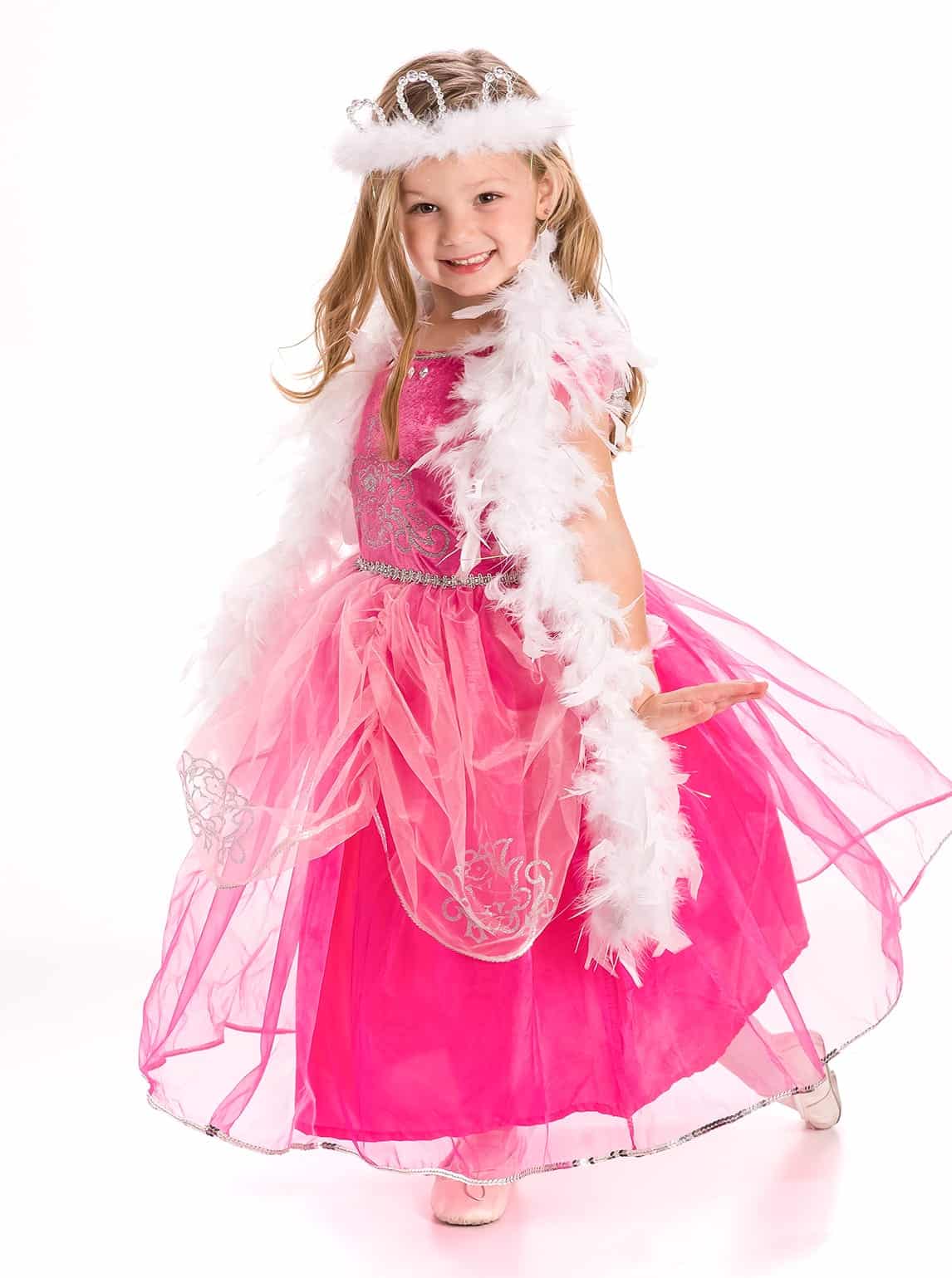 Meisje draagt de roze prinsessenjurk Deluxe Pink met zilverkleurige versieringen, een verenboa en kroontje.