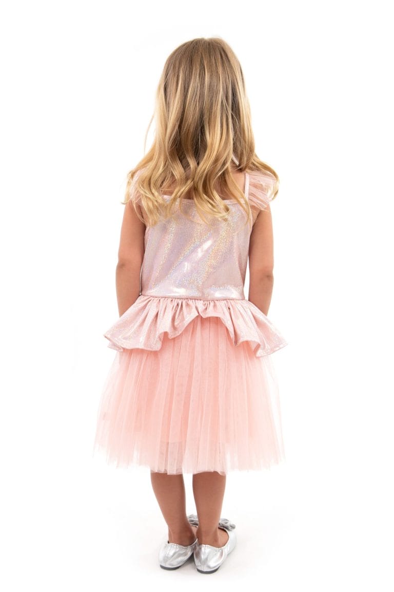 Meisje toont de achterkant van het roze tutu jurkje van Little Adventures, met glanzend lijfje en meerdere lagen tule.