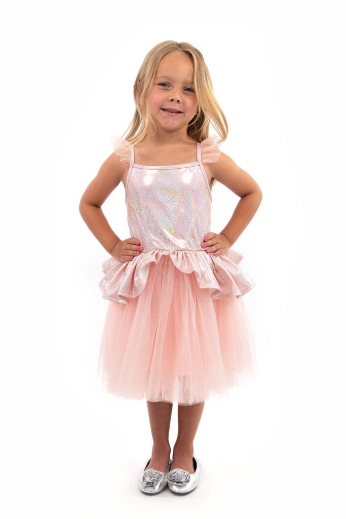 Meisje draagt een roze tutu jurk met glinsterend lijfje, tule rok en ruches bij de schouders en taille.