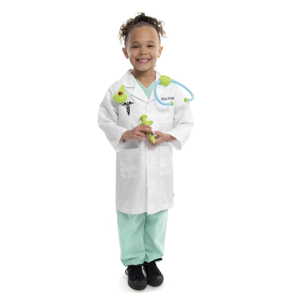 Jongen draagt de verkleedset dokter met witte laboratoriumjas, groene broek en groene speelgoedstethoscoop.