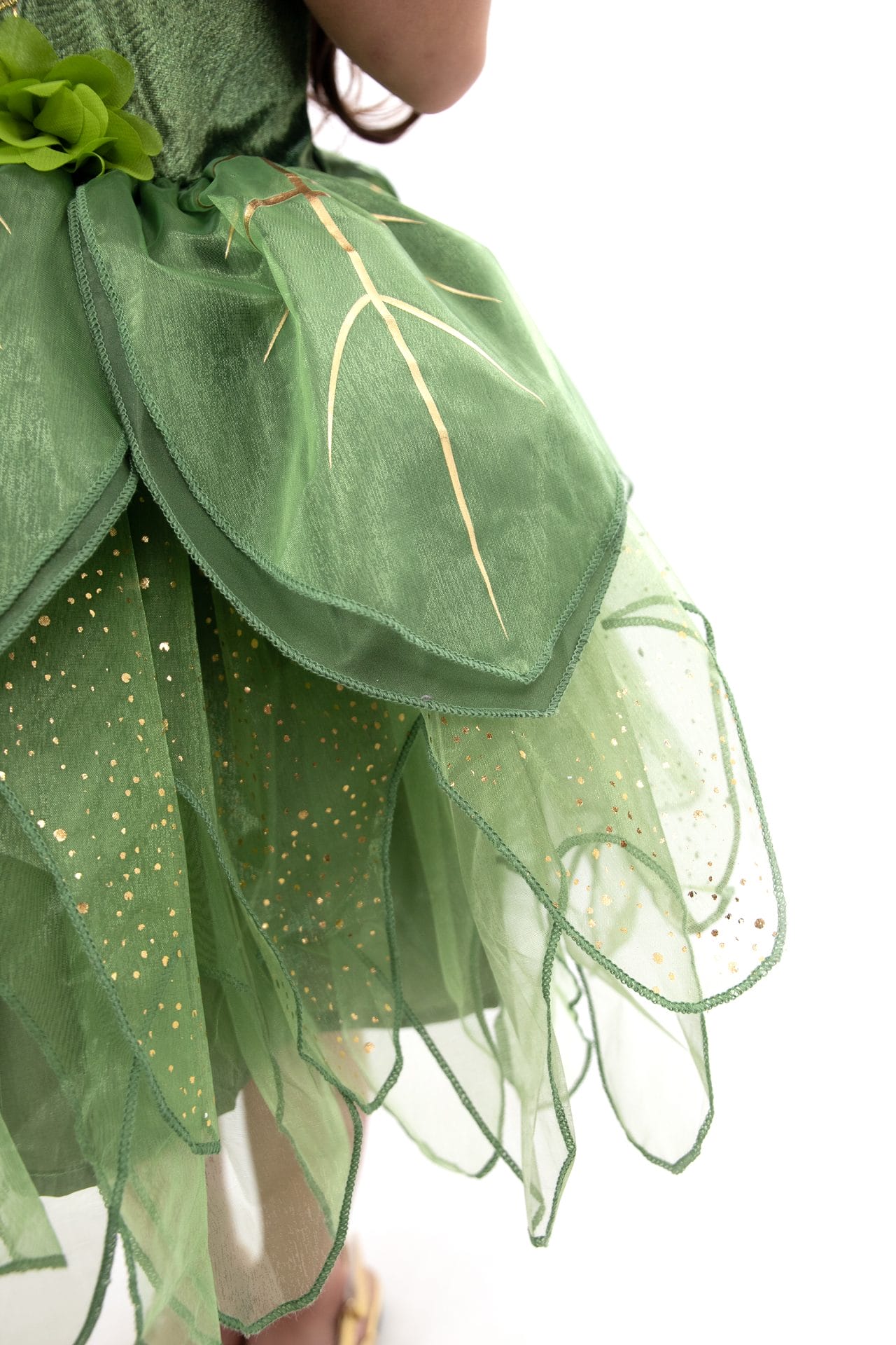 Detail van het groene tinkerbell kostuum kind met doorschijnende roklagen, gouden bladlijnen en glitters