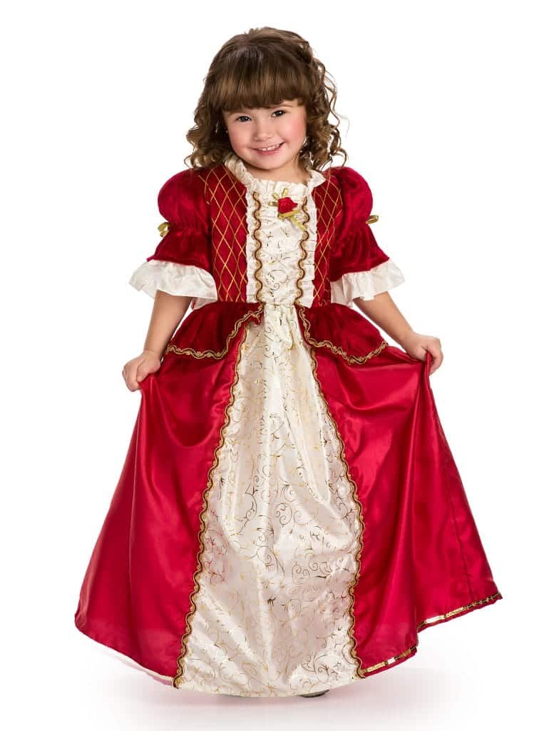 Kind draagt de Little Adventures prinsessenjurk Winter Beauty in rood en wit, met gouden biezen en een rode roos, terwijl ze de rok vasthoudt.