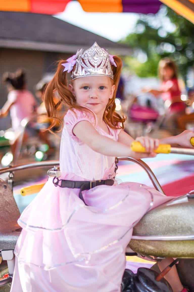 Meisje draagt de roze Royal Pink Princess prinsessenjurk van Little Adventures met zilveren details en een kroon.