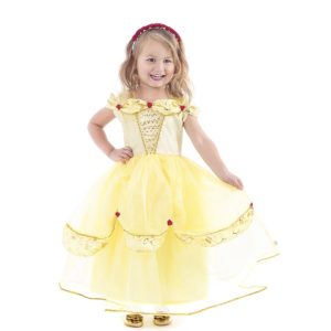 Meisje draagt een gele Belle jurk van Little Adventures met gouden sierbies, rode roosjes en een wijde organzarok.