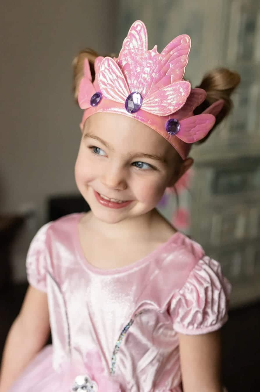 Meisje draagt de roze vlinderkroon van Little Adventures met glinsterende vleugels en paarse juwelen