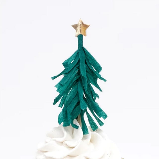 Kerstboomfiguur uit de Cupcake set Notenkraker op een wit versierde cupcake, met gouden ster
