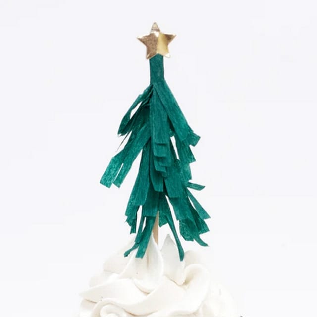 Close-up van een groene kerstboom met gouden ster uit de cupcake set kerst, bovenop witte frosting tegen een witte achtergrond.