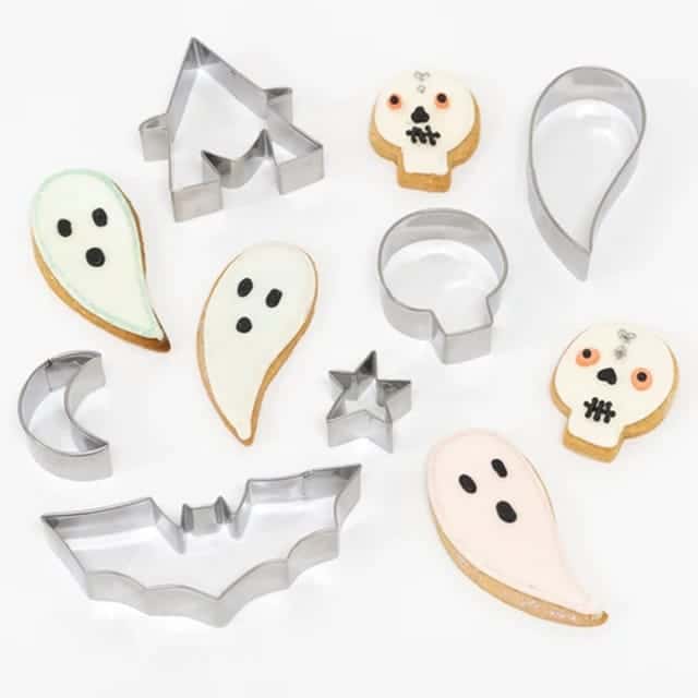 Zes meri meri cookie cutters voor Halloween, met vormen van een spook, vleermuis, ster, maan en doodskop naast koekjes