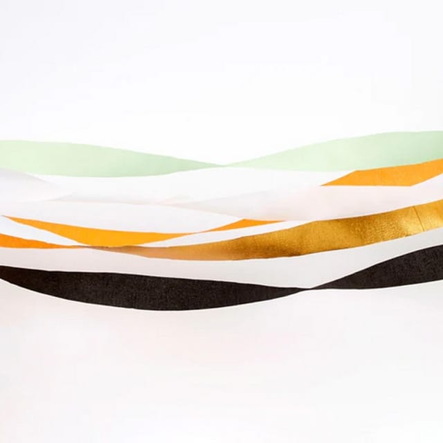 Crepepapier oranje streamers in wit, zwart, goud en mintgroen, golvend naast elkaar op een witte ondergrond.
