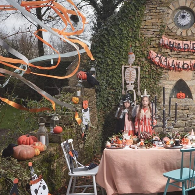 Halloweenfeest versierd met crepepapier oranje streamers van Meri Meri, tussen pompoenen en feestdecoratie