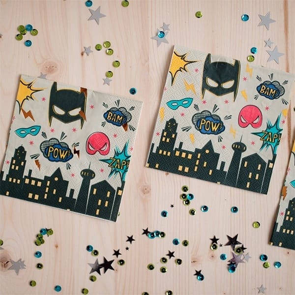 Superhero servetten met Batmanmaskers, superheldenmaskers, stripkreten en stadsgezichten op een houten tafel