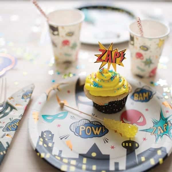 Superhero servetten met stripkreten als POW!, BAM! en ZAP! rond een cupcake op een superheldenfeest