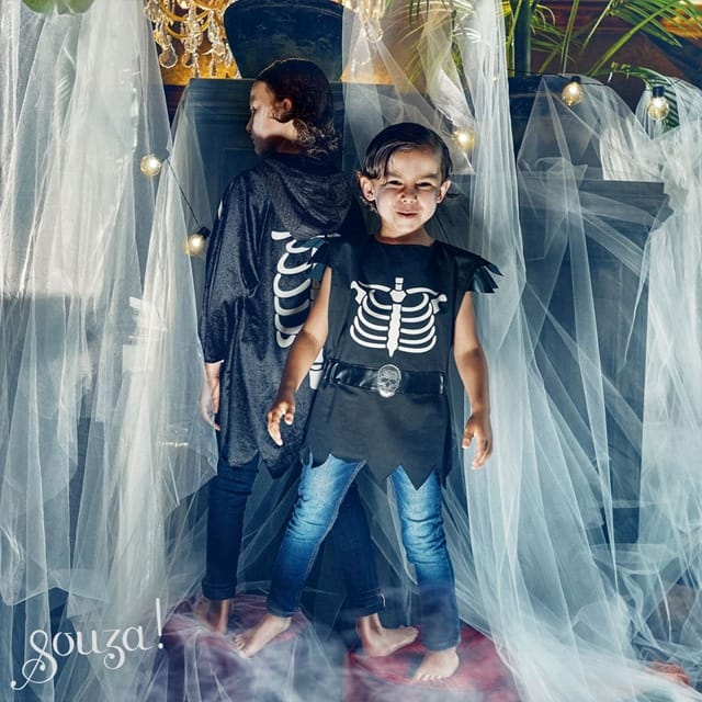 Jongen draagt de zwarte Skelet tuniek Casper met witte ribbenprint, doodskopgesp en puntige zoom tijdens Halloween