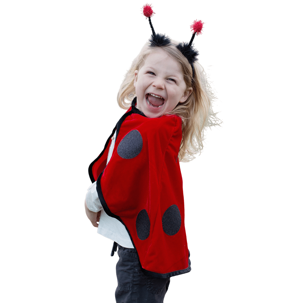 Lachend meisje in een rood lieveheersbeestje kostuum, schuin van achteren gezien met zwarte stippen en pomponhoofdband