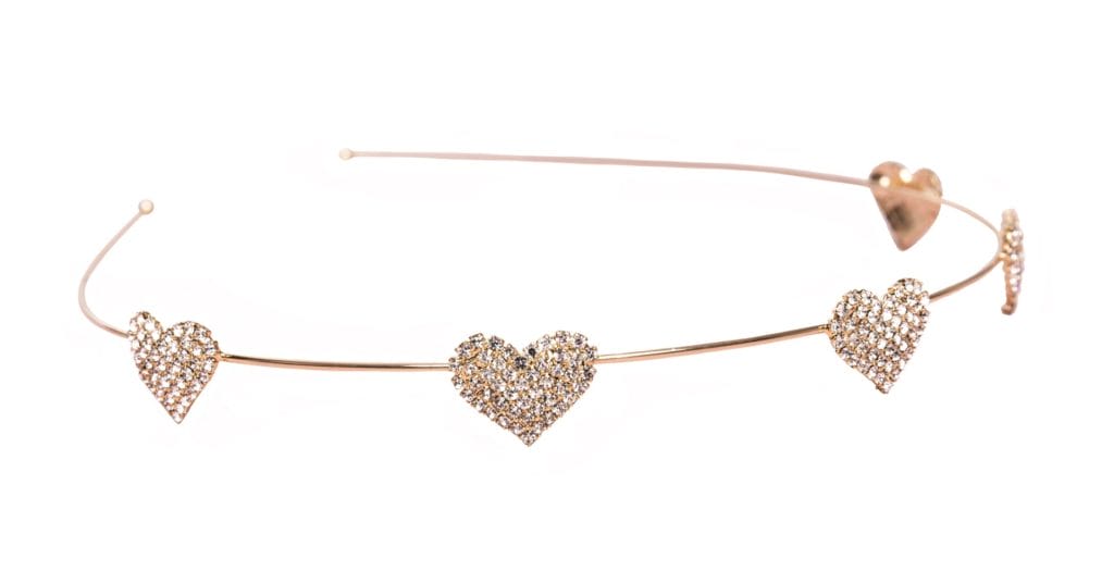 Goudkleurige Boutique Tiara Hartjes met drie strass-hartjes en een verstelbare band, liggend op een witte achtergrond