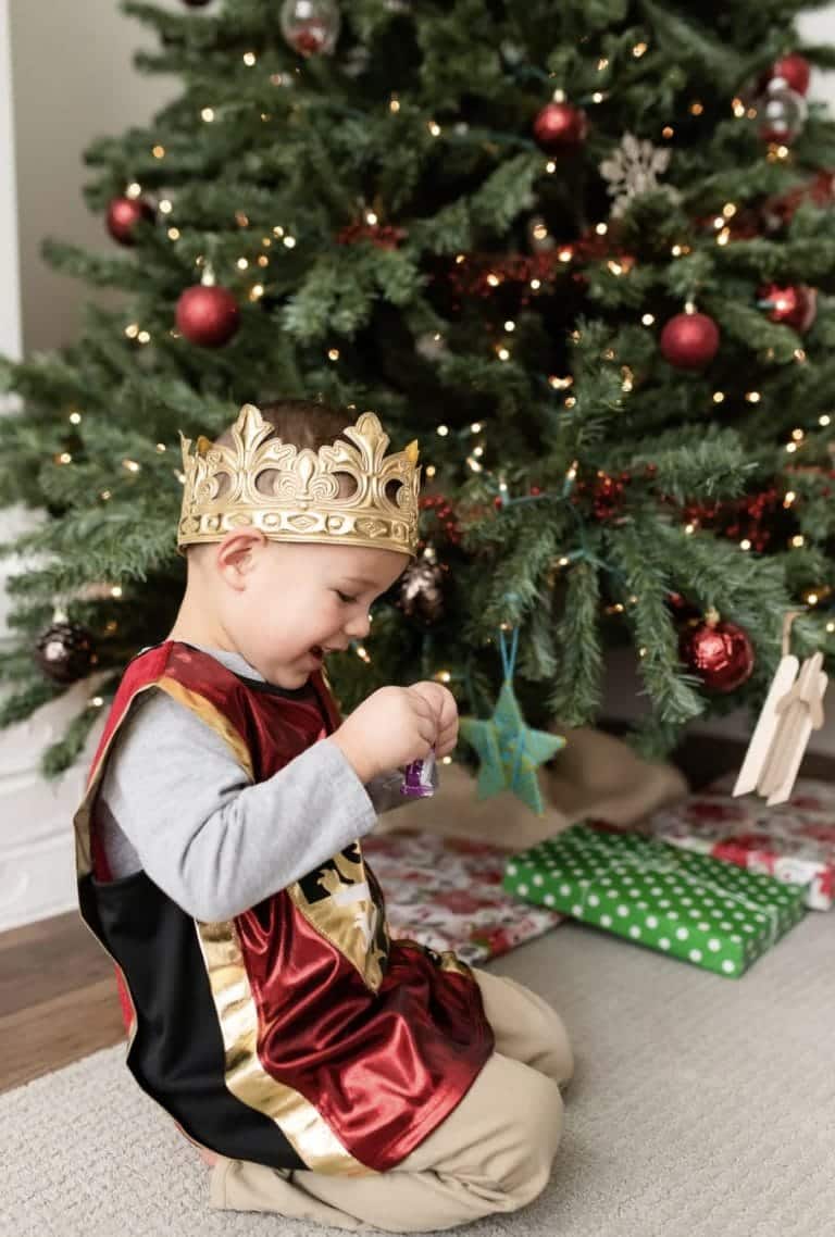 Jongen draagt het rode ridder vest van Little Adventures met goudkleurige details en zwart achterpand