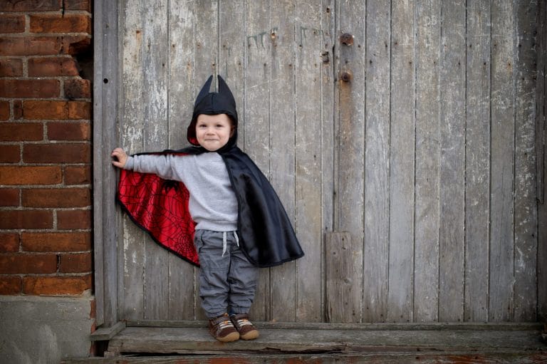 Kind als batman in cape met zwarte buitenkant, rode spinnenwebvoering en puntige capuchon