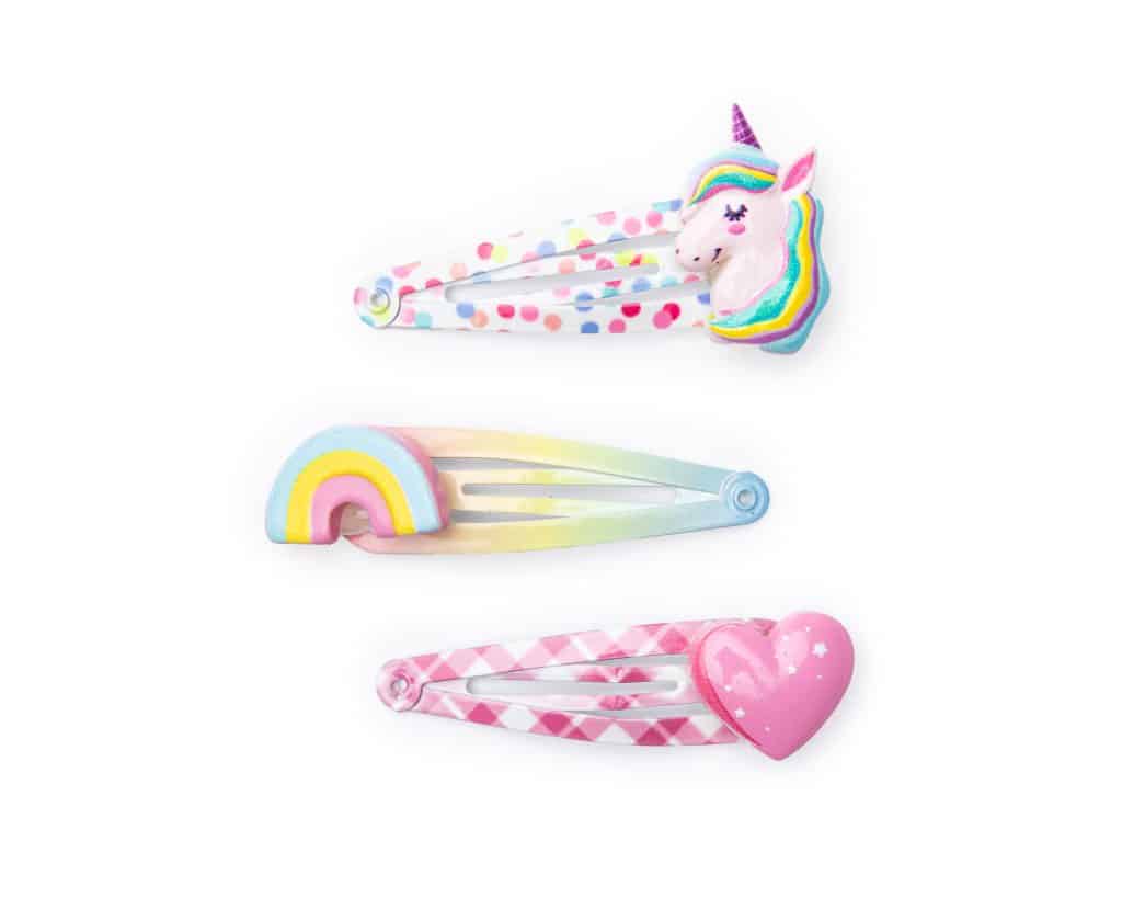 Set van drie Great Pretenders haarclips met unicorn-, regenboog- en hartversieringen op witte achtergrond.