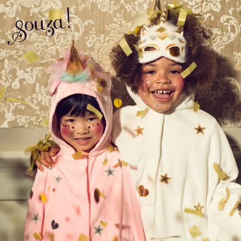 Kind draagt de witte souza cape als eenhoorncape met capuchon, gouden sterren en een bijpassend eenhoornmasker.