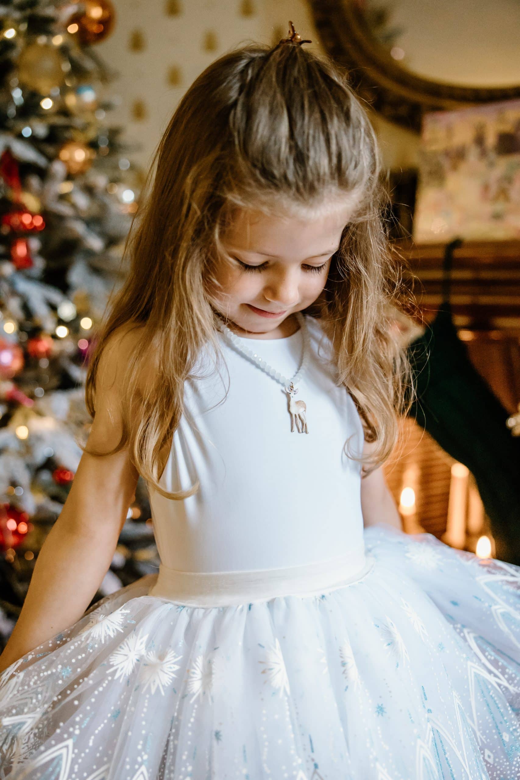 Van dichtbij is de witte tutu rok met glinsterende sterrenprint zichtbaar rond de taille van een meisje.