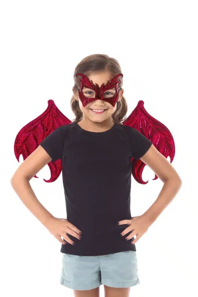 Meisje draagt de rode Little Adventures draken vleugels en een bijpassend masker, frontaal met handen in de zij.
