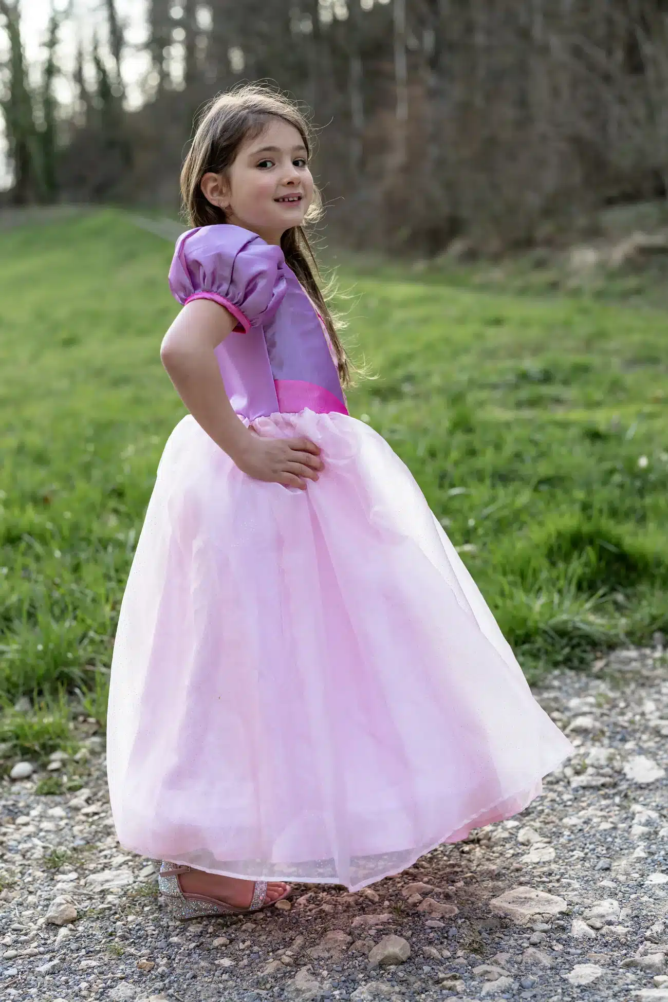 Meisje draagt een paarse en roze prinsessenjurk Rapunzel van Great Pretenders met wijde tule rok buiten