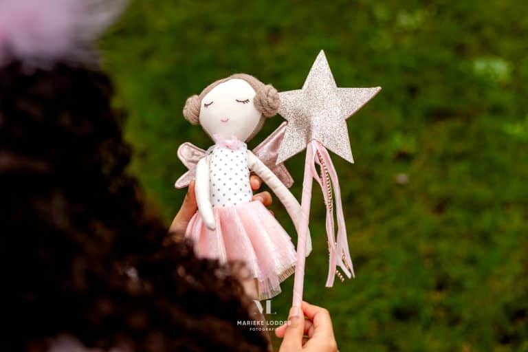 Prinsessen toverstaf met glinsterende ster en roze linten naast een stoffen prinsessenpop met vleugels