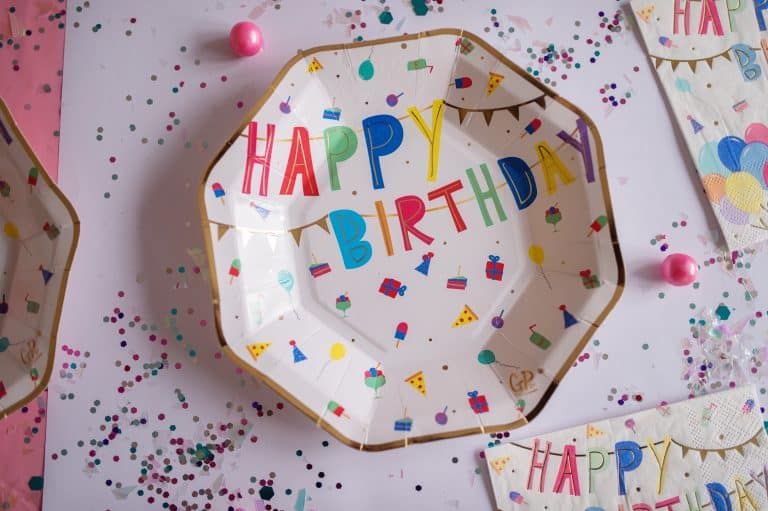 Great Pretenders Happy Birthday partybordje voor een thema kinderfeestje, met kleurrijke letters en goudkleurige rand
