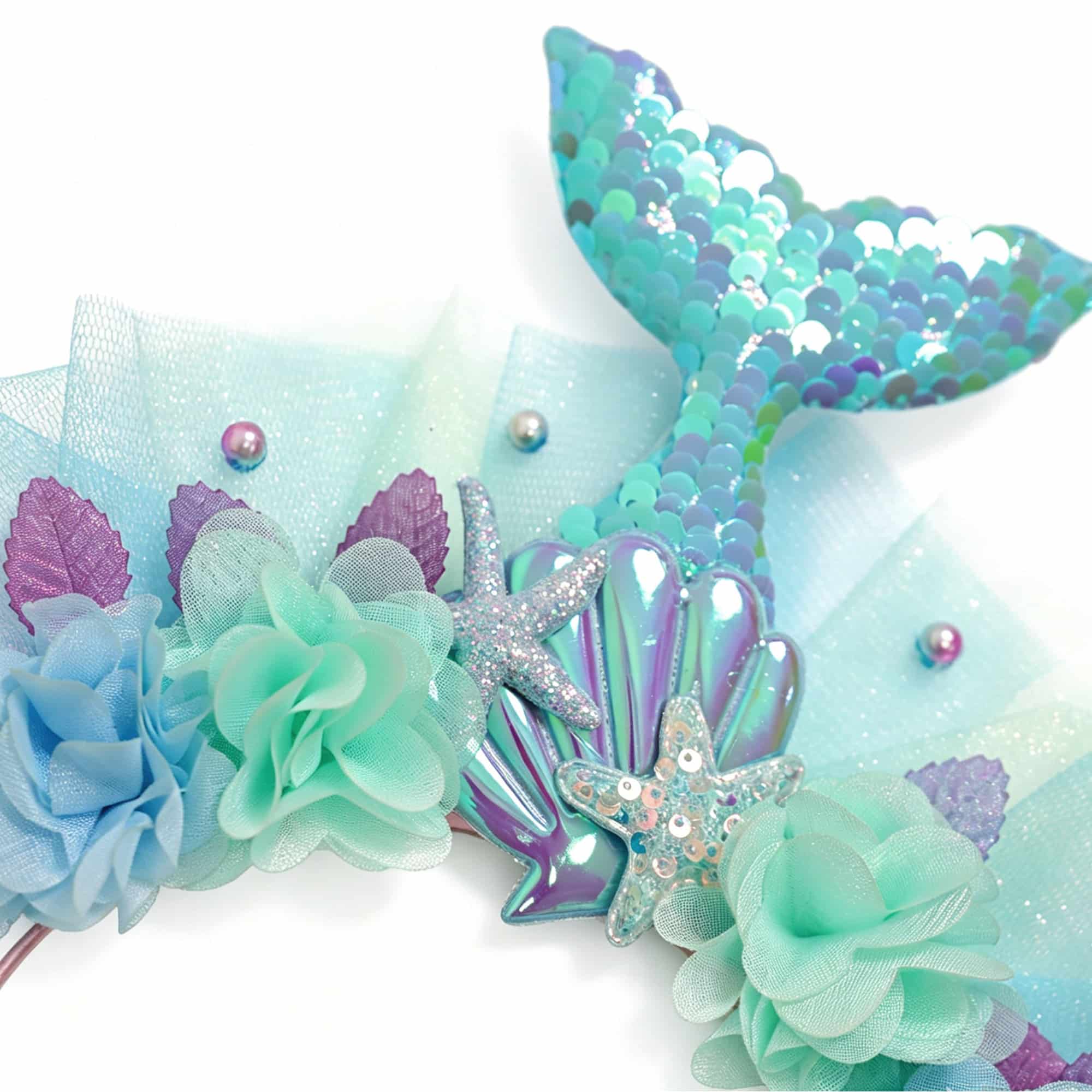 Detail van de zeemeermin diadeem met blauwe bloemen, tule, schelpversiering en glanzende zeemeerminstaart